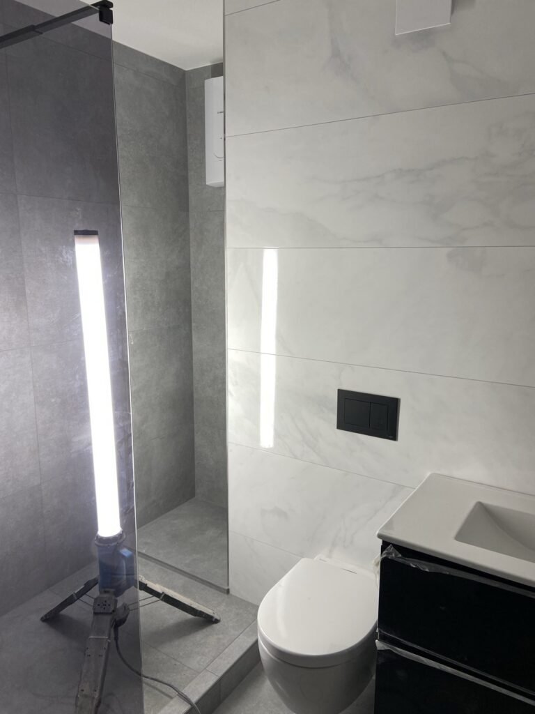Badezimmer mit eingelassener Nische und dunklen Armaturen