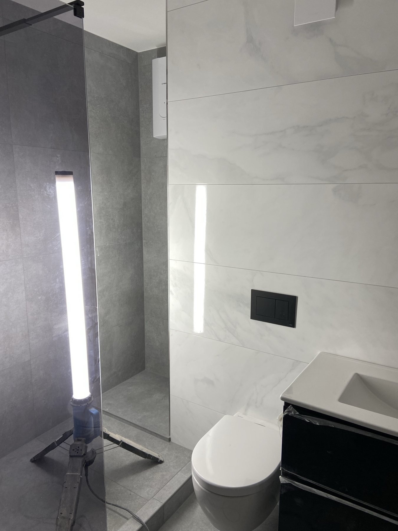 Badezimmer mit eingelassener Nische und dunklen Armaturen