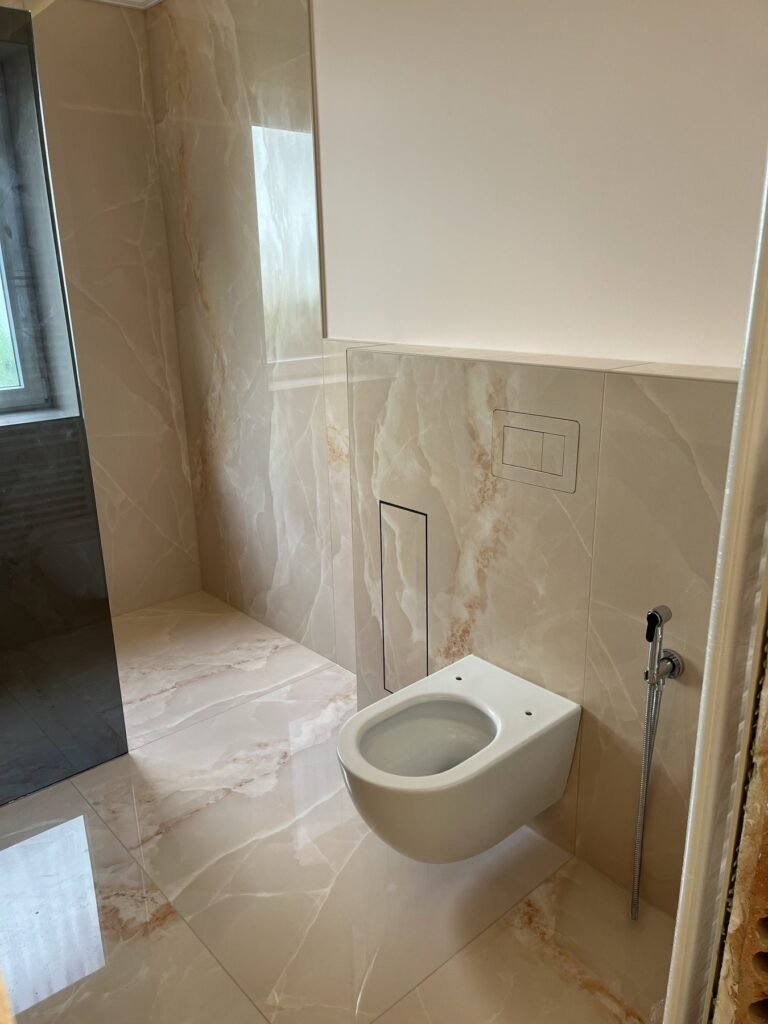 Wand-WC neben bodentiefem Fenster