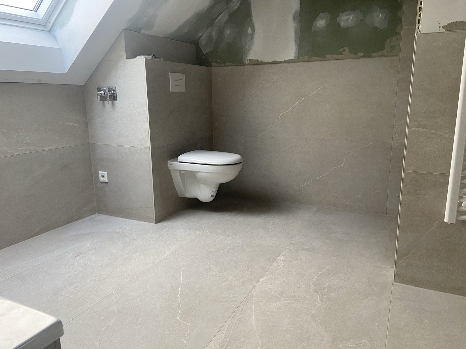 Wand-WC und helle Bodenfliesen im Ausbau