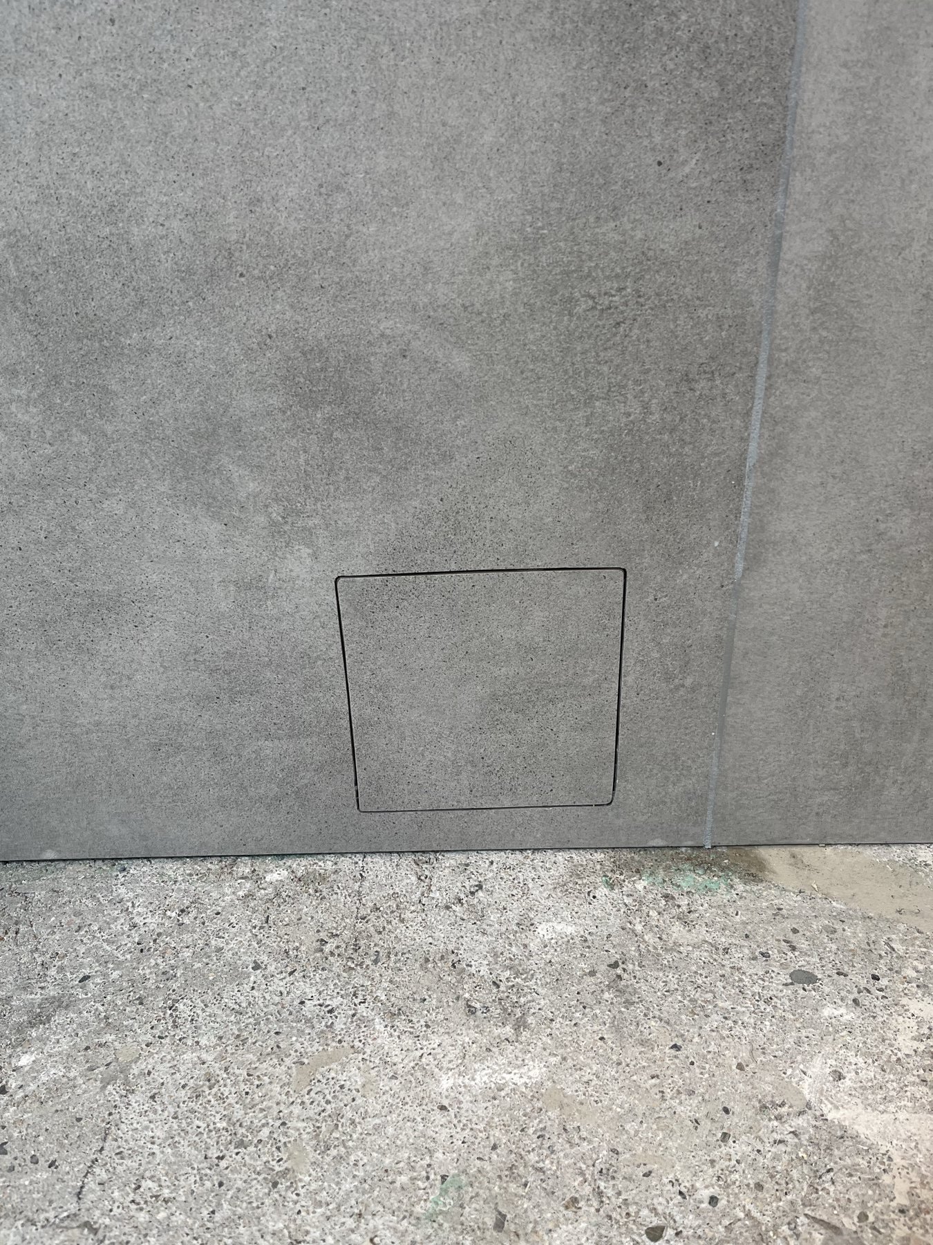 Flächenbündiges Detail in einer grauen Fliesenwand