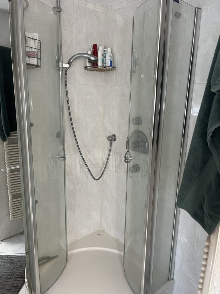 Dusche mit Glasabtrennung und Wandarmatur