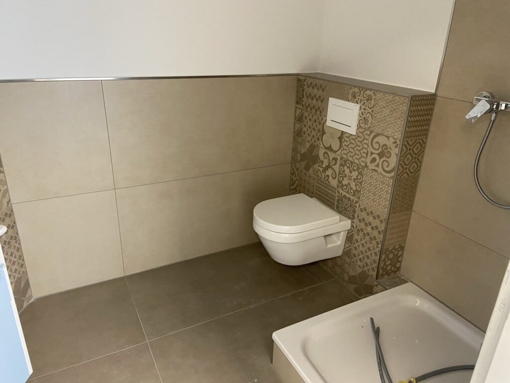 WC-Bereich mit beige-grauen Dekorfliesen