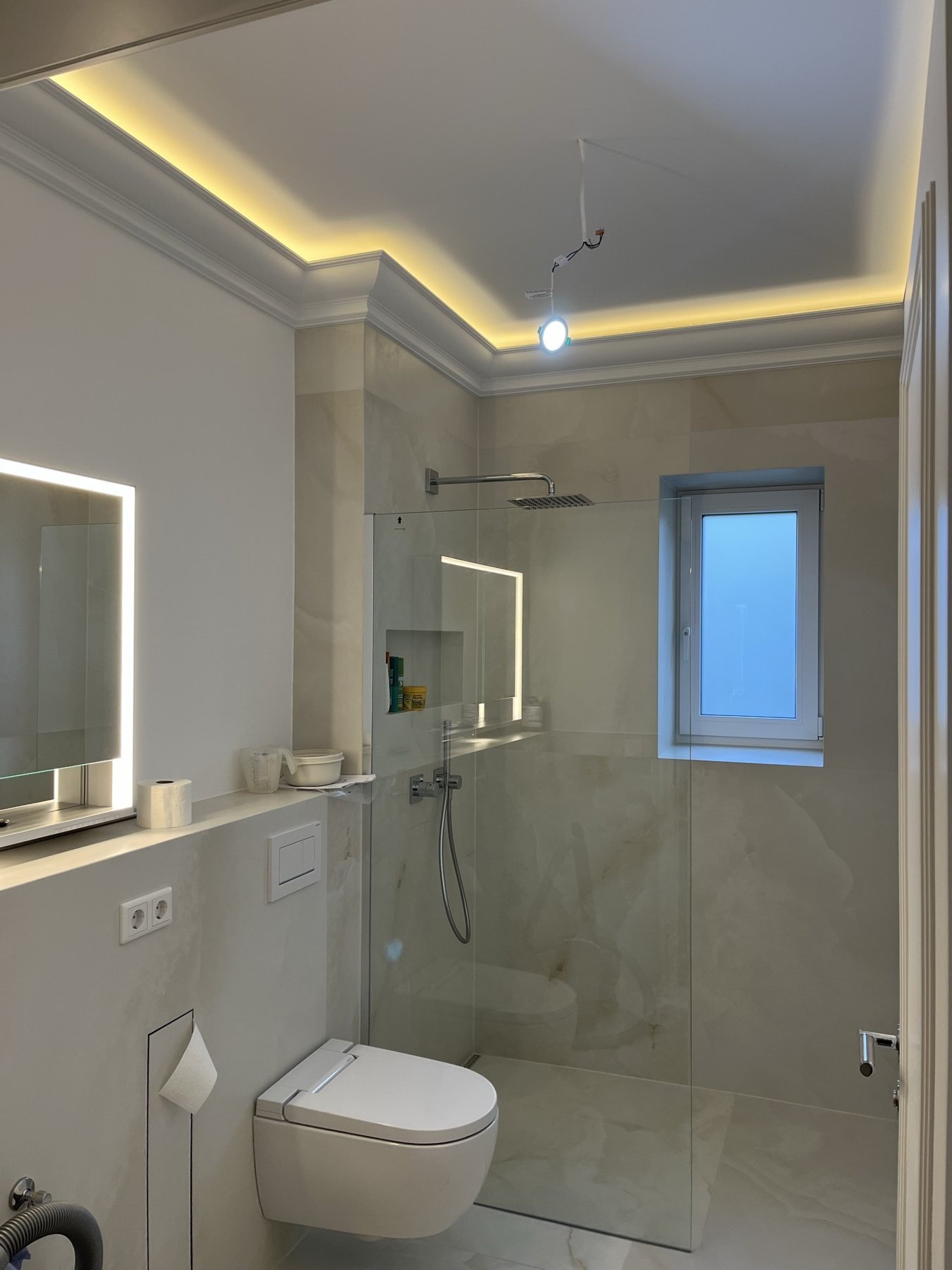 Badezimmer mit Waschtisch und indirekter Deckenbeleuchtung
