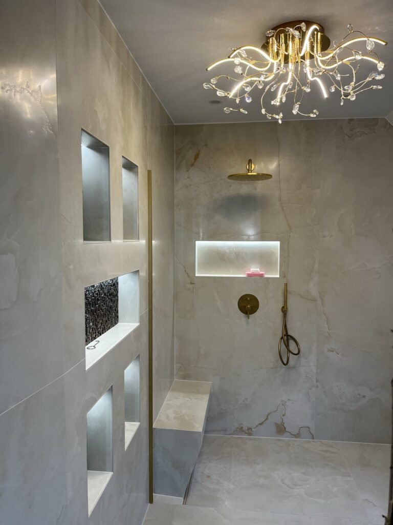 Badezimmer mit beleuchteter Nischenwand und Kronleuchter