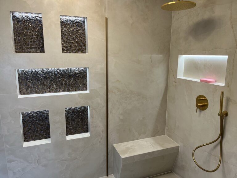 Dusche mit Sitzbank und beleuchteten Ablagen